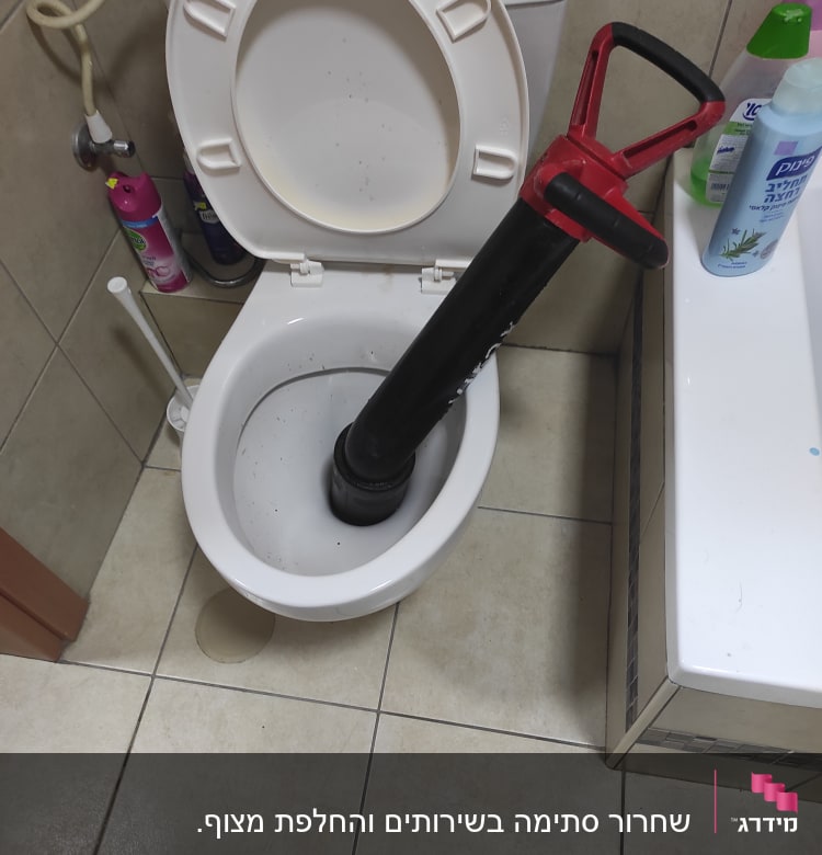 בוכנה שחורה בתוך אסלה פתוחה בחדר אמבטיה